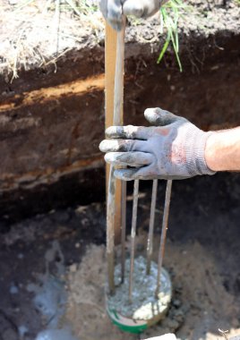 Çimento işi devam ediyor. Temel dayanıklılık işi. Bir kova beton, topraktaki takviye çelik. Ev yenileme konsepti. 