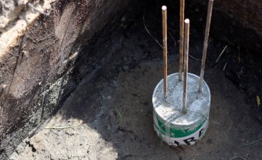 Çimento işi devam ediyor. Temel dayanıklılık işi. Bir kova beton, topraktaki takviye çelik. Ev yenileme konsepti. 