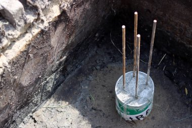 Çimento işi devam ediyor. Temel dayanıklılık işi. Bir kova beton, topraktaki takviye çelik. Ev yenileme konsepti. 
