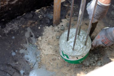 Çimento işi devam ediyor. Temel dayanıklılık işi. Bir kova beton, topraktaki takviye çelik. Ev yenileme konsepti. 