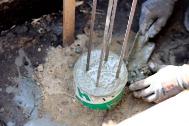 Dayanıklılık süreci devam ediyor. Bir kova beton, topraktaki takviye çelik. Ev yenileme konsepti. 