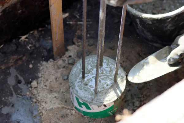 Dayanıklılık süreci devam ediyor. Bir kova beton, topraktaki takviye çelik. Ev yenileme konsepti. 