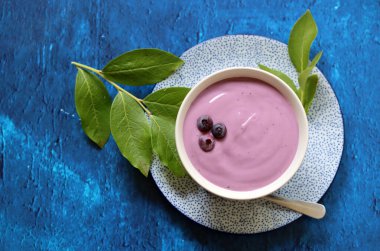 Seramik kasede ev yapımı yabanmersinli yoğurt. Masada sağlıklı bir kahvaltı. Dengeli diyet kavramı. 
