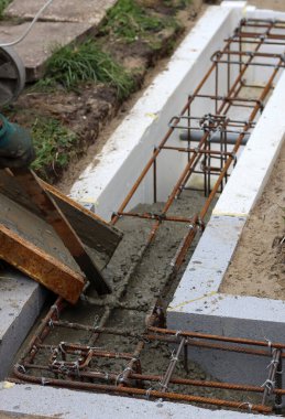 Foundation strength works in process. Reinforcement steel bars, concrete mixer, cement close up photo. Home renovation concept.  