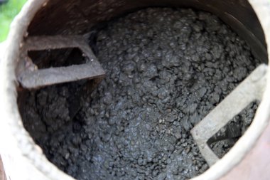 Concrete mixer close up photo. Construction worker equipment. Industrial cement mortar standing outdoors. 