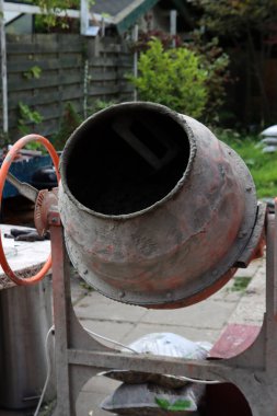 Concrete mixer close up photo. Construction worker equipment. Industrial cement mortar standing outdoors. 