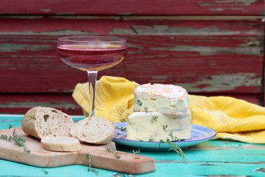 Still life with rose wine, brie cheese and bread on a table. French food concept. Summer picnic in the garden. 