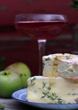 Still life with rose wine, brie cheese and bread on a table. French food concept. Summer picnic in the garden. 