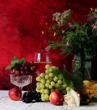 Still life with cheese and wine on a table. Delicious French cheese and glass of a pink wine. Colorful photo of tasty delicatessen.  