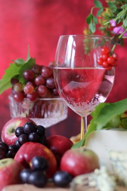 Wine and fruit on a table. Beautiful composition of juicy berries, grapes and rose wine. Harvest celebration. Textured background with copy space. 