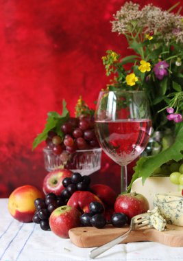 Wine and fruit on a table. Beautiful composition of juicy berries, grapes and rose wine. Harvest celebration. Textured background with copy space. 