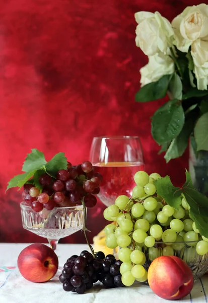 Wine and fruit on a table. Beautiful composition of juicy berries, grapes and rose wine. Harvest celebration. Textured background with copy space. 
