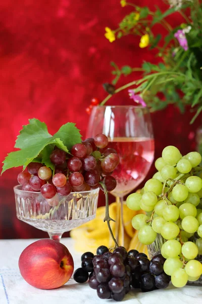 Wine and fruit on a table. Beautiful composition of juicy berries, grapes and rose wine. Harvest celebration. Textured background with copy space. 