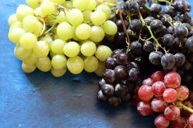 Black, green and red grapes on close up.  Top view photo of seasonal fruits. Healthy eating concept. 
