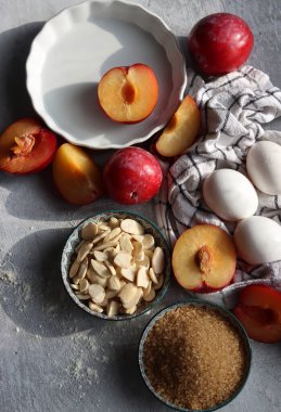 Masadaki tatlı pasta malzemeleri. Eriklerin, yumurtaların, esmer şekerlerin ve bademlerin yakın fotoğrafını çek. Meyveli turta yapıyorum. Sağlıklı yeme kavramı. 