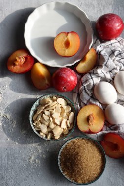 Masadaki tatlı pasta malzemeleri. Eriklerin, yumurtaların, esmer şekerlerin ve bademlerin yakın fotoğrafını çek. Meyveli turta yapıyorum. Sağlıklı yeme kavramı. 