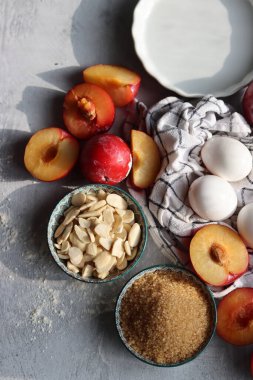 Masadaki tatlı pasta malzemeleri. Eriklerin, yumurtaların, esmer şekerlerin ve bademlerin yakın fotoğrafını çek. Meyveli turta yapıyorum. Sağlıklı yeme kavramı. 
