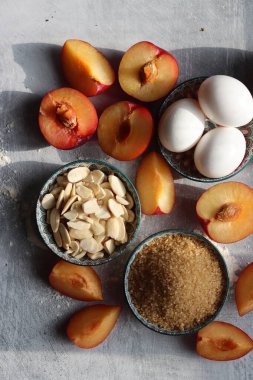 Erikli turta işleniyor. Masadaki taze malzemeler. Eriklerin, bademlerin, demerara şekerinin ve yumurtaların en iyi görüntüsü. Tatlı kek malzemeleri kapanıyor.. 