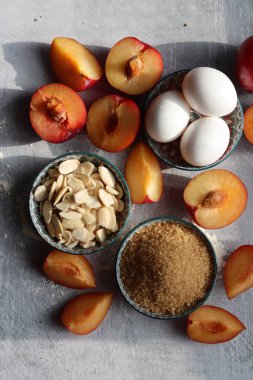 Erikli turta işleniyor. Masadaki taze malzemeler. Eriklerin, bademlerin, demerara şekerinin ve yumurtaların en iyi görüntüsü. Tatlı kek malzemeleri kapanıyor.. 