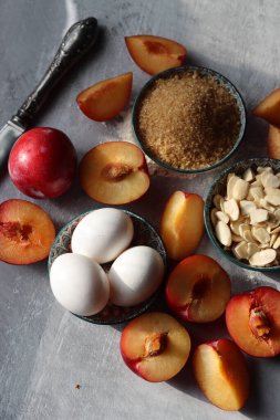 Masadaki tatlı pasta malzemeleri. Eriklerin, yumurtaların, esmer şekerlerin ve bademlerin yakın fotoğrafını çek. Meyveli turta yapıyorum. Sağlıklı yeme kavramı. 