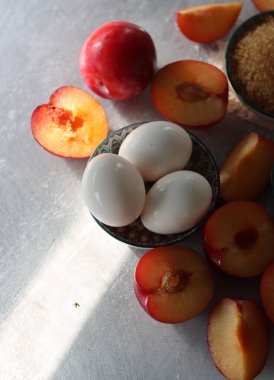 Masadaki tatlı pasta malzemeleri. Eriklerin, yumurtaların, esmer şekerlerin ve bademlerin yakın fotoğrafını çek. Meyveli turta yapıyorum. Sağlıklı yeme kavramı. 