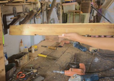 Elindeki yazı için ahşap tahta. Elde ahşap kalaslar. Marangozluk çalışma masası geçmişi.