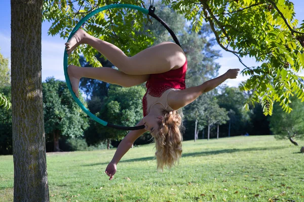Молодая Блондинка Красном Платье Вечеринки Тренирующаяся Воздушном Обруче Свисающем Дерева — стоковое фото