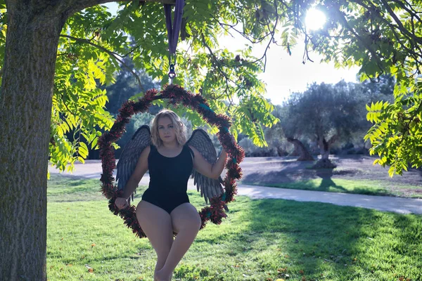날개를 여자가 나무에 매달려 훌라후프에 할로윈 하늘을 곱슬곱슬 — 스톡 사진