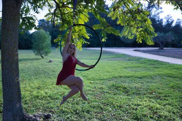 드레스를 여자가 가운데 나무에 매달려 공중에서 운동을 있습니다 에어쇼 곱슬머리 — 스톡 사진