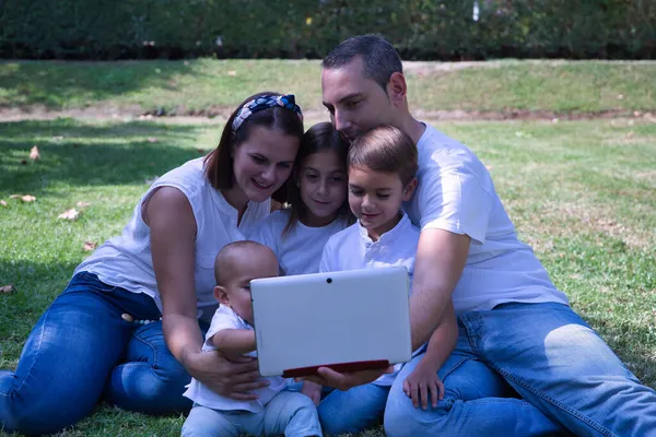 Happy Keluarga Besar Lima Duduk Rumput Taman Melihat Tablet Dengan — Stok Foto