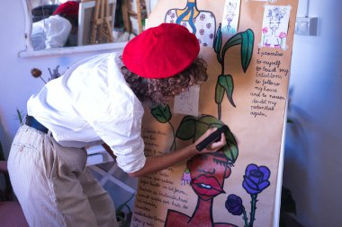 Genç bir kadın, sanatçı, tasarımcı ve ressam atölyesinde siyah bir kalemle eserlerinden biri üzerinde çalışıyor. Konsept resim, çizim, tasarımcı, sanatçı, modern.