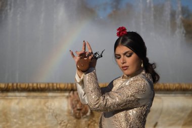 Genç flamenko kadın portresi, İspanyol ve esmer, tipik flamenko dans takımı, boğa güreşçisi ceketi ve kastanet çalan. Flamenko kavramı, dansçı, tipik İspanyol dansı..