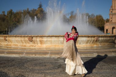 Genç flamenko kadın, İspanyol ve esmer, tipik flamenko dans takımı ile, altın çiçeklerle kırmızı manila şalla dans ediyor. Flamenko konsepti, dansçı, tipik İspanyol dansı..