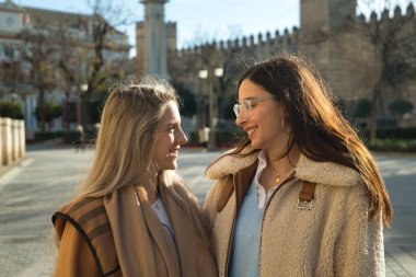 Gerçek bir çift genç kadın, birbirlerine sevgi dolu bir tavırla sarılıp gözlerinin içine bakıyorlar. Kavram lgtbiq +, lezbiyenler, aşık, dahil olma.