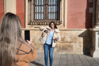 Gerçek bir çift genç kadın, cep telefonuyla videolar kaydediyor. Sorunları için mobil uygulamalar ve sosyal ağlar kullanıyorlar. Kavram makarası, video, dans, meydan okuma.