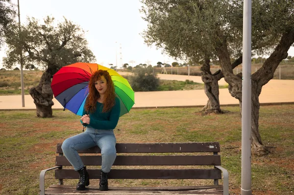 Mujer Joven Pelirroja Pecas Con Paraguas Arco Iris Sentada Banco — Foto de Stock