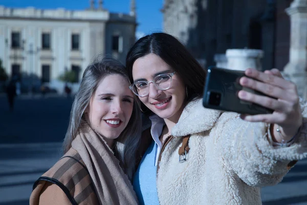 Portret Prawdziwej Pary Młodych Kobiet Przytulających Się Siebie Telefonem Podczas — Zdjęcie stockowe