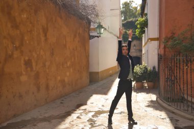 Ceketli, pantolonlu, siyah dans ayakkabılı, beyaz gömlekli, yeşil yelekli, sokakta flamenko dansı yapan genç bir İspanyol. Tipik İspanyol konsepti, sanat, dans, kültür, gelenek.