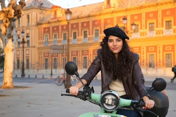 若いと美しい女性の肖像画 ブルネット 巻き毛を持つ 革のジャケットと黒ベレー帽と 街を訪問しながら レンタルバイクにマウントされています コンセプトの美しさ ファッション — ストック写真