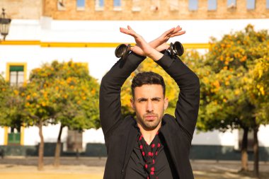 Siyah gömlek ve ceket giyen, kırmızı noktalı siyah mendilli ve kastanyetli genç İspanyol 'un portresi sokakta flamenko dansı yapıyor. Sanat, dans, kültür, gelenek.