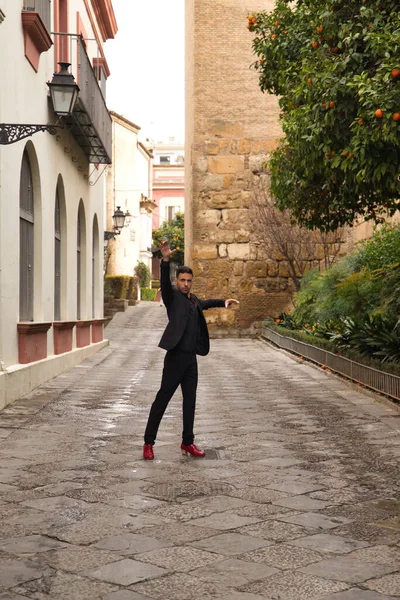 若いスペイン人男性は 黒のシャツ ジャケット パンツを着て 赤いダンスシューズで 通りでフラメンコを踊ります スペインの代表的なコンセプト ダンス — ストック写真