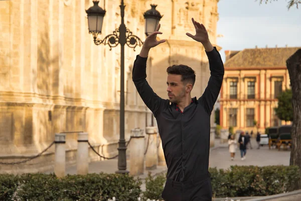 Siyah gömlek ve pantolon giymiş, sokakta flamenko dansı yapan genç İspanyol 'un portresi. Tipik İspanyol konsepti, sanat, dans, kültür, gelenek.