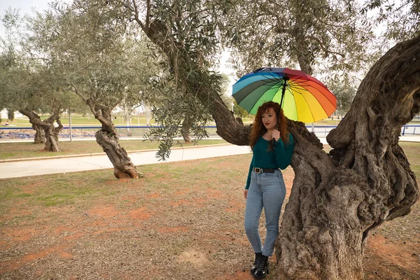 Genç Bir Kadın Kızıl Saçlı Çilli Gökkuşağı Şemsiyeli Zeytin Ağacının — Stok fotoğraf