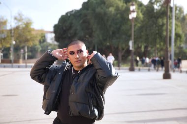 İkili olmayan, genç ve Güney Amerikalı, aşırı makyajlı, tamamen siyah giyinmiş, Avrupa 'da tatilde poz veriyor. Kavram kraliçesi, lgbtq +, gurur, nonoş.