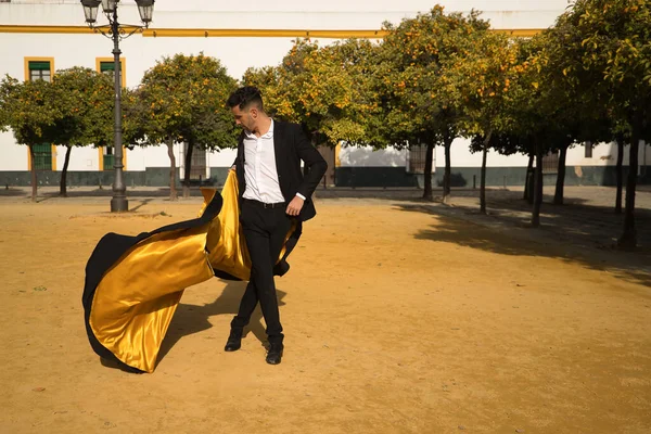 Siyah gömlekli, ceketli ve pantolonlu, dans ayakkabılı, siyah ve altın pelerinli, flamenko dansı yapan genç bir İspanyol. Tipik İspanyol konsepti, sanat, dans, kültür, gelenek.