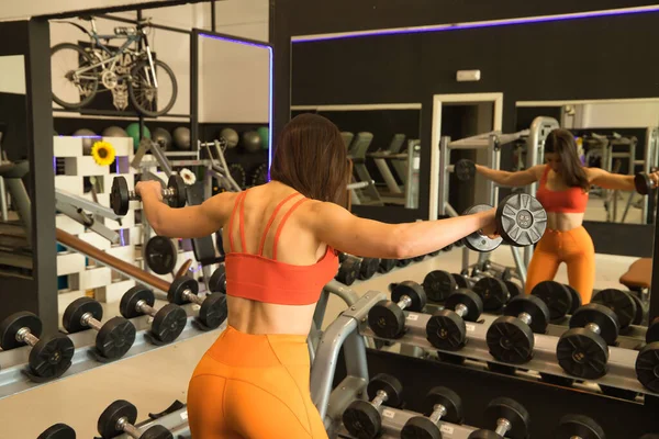 Молодая Красивая Женщина Выполняет Упражнения Плечо Гантелями Отражающимися Зеркале Спортзала — стоковое фото