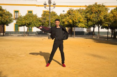 Siyah tişörtlü, ceketli ve pantolonlu, kırmızı dans ayakkabılı, siyah mendilli, kırmızı benekli genç bir İspanyol. Sanat, dans, kültür, gelenek.