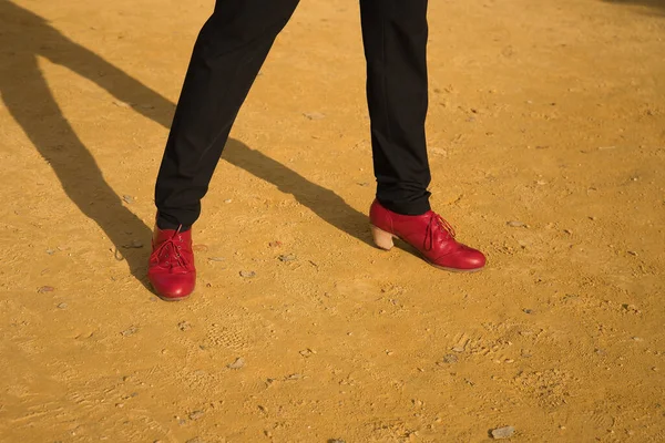 Detail of red colored flamenco dance shoes for men, on an albero floor. Typical Spanish concept, art, dance, culture, tradition.