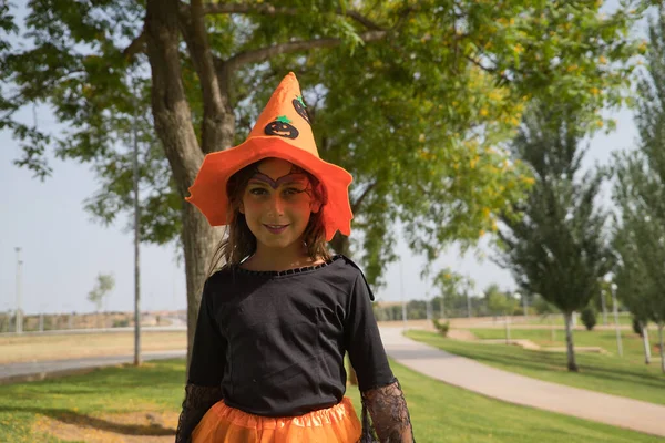 오렌지 치마를 할로윈을 축하하는 공원에서 모자를 소녀의 컨셉트 속임수아니면 — 스톡 사진