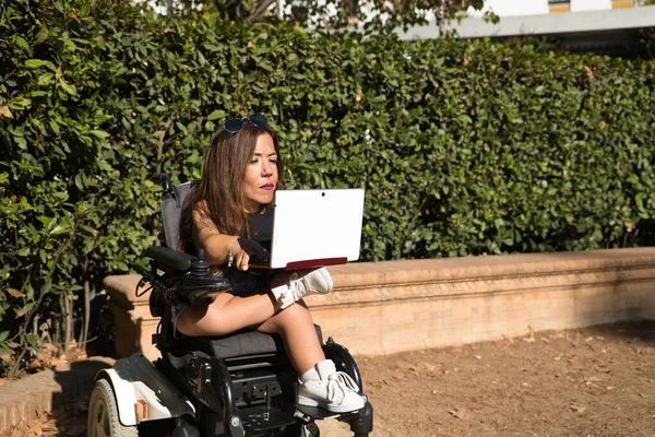 실외에서 노트북 컴퓨터와 휠체어를 일하던 장애인 여성이었습니다 기본적 — 스톡 사진